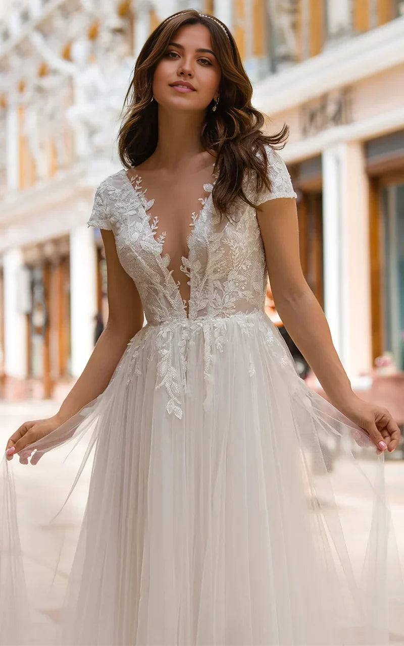 Vestido de novia de tul con cola larga, escote pronunciado y corte en A con apliques